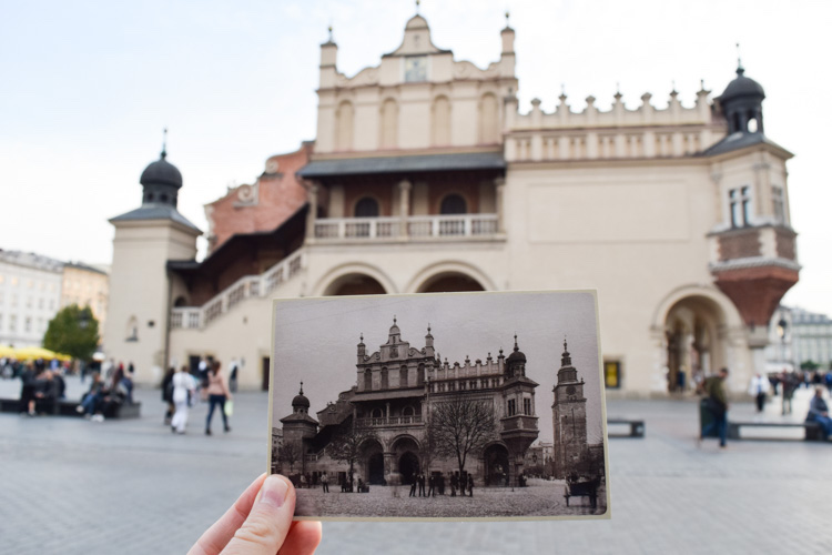 Hand holding an old image of the same building behind it. Krakow Poland