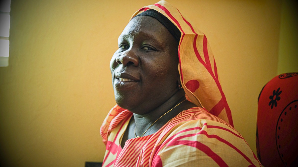 Woman smiling at the camera in Senegal in bright dress - photo by Larissa Rolley, photography course creator at Wanderful